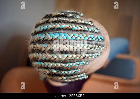 Cornrows femmes Une femme avec une coupe de cheveux sur un fond blanc, des tresses serrées tressées dans une queue, matériel artificiel tissé dans lui Banque D'Images