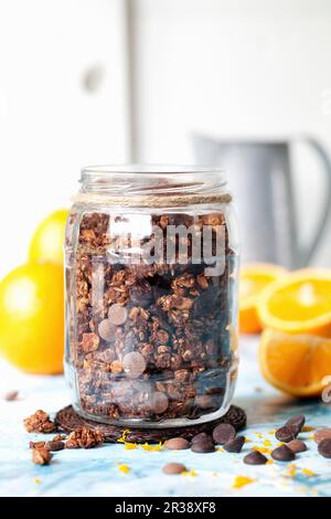 Chocolate orange granola dans un pot avec des oranges fraîches Banque D'Images