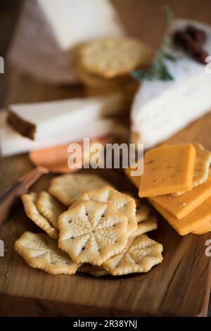 Craquelins et différents types de fromage sur une planche en bois Banque D'Images