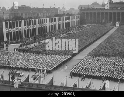 Jeux olympiques de Berlin 1936. Les Jeux Olympiques d'été 1936 (en allemand : Olympiche Sommerspiele 1936), officiellement connus sous le nom de Jeux de la XI e Olympiade (en allemand : Spiele der XI Olympiade), connue sous le nom de Berlin 1936, était un événement multisport international qui s'est tenu du 1 au 16 août 1936 à Berlin, en Allemagne. Photographiée la flamme olympique transportée à l'Olympiastadion de Berlin par des coureurs, cette cérémonie est appelée relais de la torche olympique. Les drapeaux nazis y sont suspendus. Banque D'Images