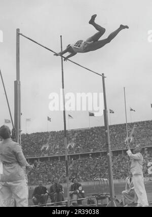 Jeux olympiques de Berlin 1936. Les Jeux Olympiques d'été 1936 (en allemand : Olympiche Sommerspiele 1936), officiellement connus sous le nom de Jeux de la XI e Olympiade (en allemand : Spiele der XI Olympiade), connue sous le nom de Berlin 1936, était un événement multisport international qui s'est tenu du 1 au 16 août 1936 à Berlin, en Allemagne. Photo de l'athlète suédois Ljungberg pendant son saut de la voûte polaire à l'Olympiastadion à Berlin. Banque D'Images