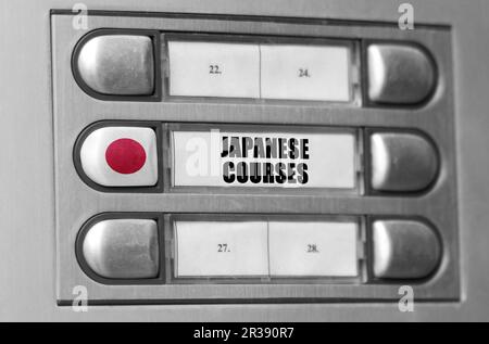 Sur l'interphone il y a un bouton avec le drapeau du Japon et l'inscription - cours de langue japonaise. Banque D'Images