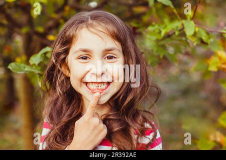 Enfant pointant récemment a éclaté dent avant permanente Banque D'Images