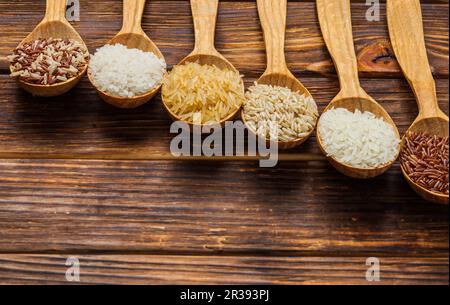 Pelles en bois avec différents types de riz sur la table Banque D'Images