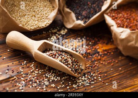 Mélanger les graines de quinoa dans la pelle en bois Banque D'Images