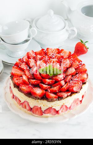 Gâteau à la fraise Fraisier sur la plaque blanche et tasses pour le temps du thé Banque D'Images