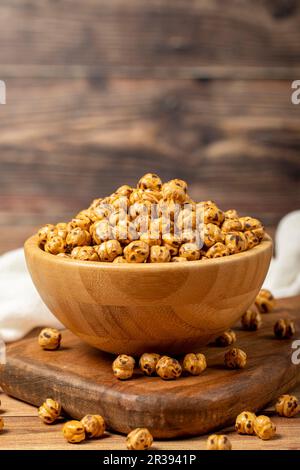 Pois chiches rôtis. Pois chiches rôtis dans un bol en bois. Superfood concept de la nourriture végétarienne. des collations saines. Gros plan Banque D'Images
