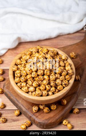 Pois chiches rôtis. Pois chiches rôtis dans un bol en bois. Superfood concept de la nourriture végétarienne. des collations saines. Gros plan Banque D'Images