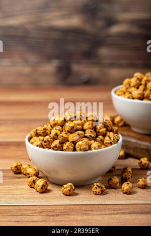 Pois chiches rôtis. Pois chiches rôtis dans un bol en céramique. Superfood concept de la nourriture végétarienne. des collations saines. Gros plan Banque D'Images