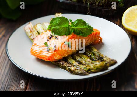 Saumon grillé et asperges au citron sur la plaque blanche Banque D'Images