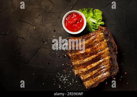 Côtes de porc grillées tranchées au barbecue avec sauce Banque D'Images