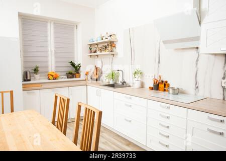 Cuisine lumineuse et ensoleillée avec mur en marbre blanc. Banque D'Images