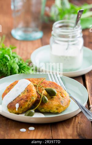 Gâteaux au saumon fumé avec câpres et sauce au yaourt Banque D'Images