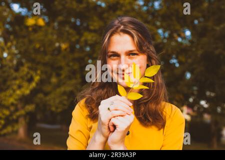 Portrait of young woman with autumn leaf Banque D'Images