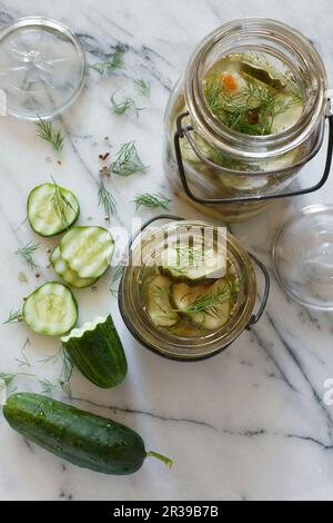 Cornichons entiers et en tranches marinés dans des jarres de verre vintage Banque D'Images