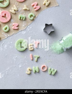 Les mots « Lay IT Snow » se découpent d'une pâtisserie colorée Banque D'Images