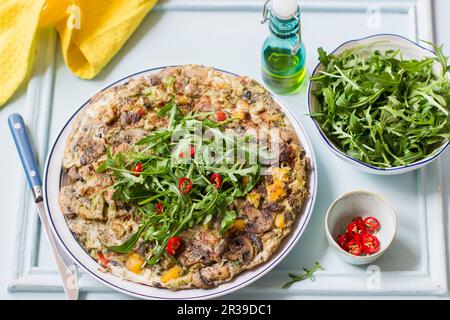 Frittata aux champignons, poivrons rouges et jaunes, roquette et piments frais Banque D'Images