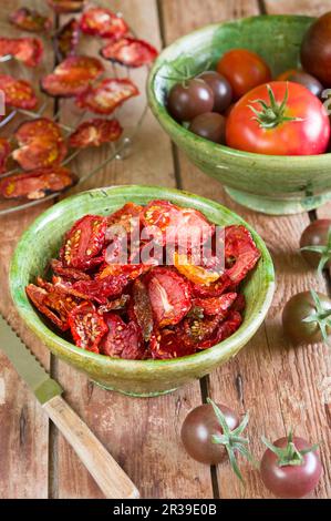 Tomates séchées sur un support en fil métallique et dans un bol en céramique Banque D'Images