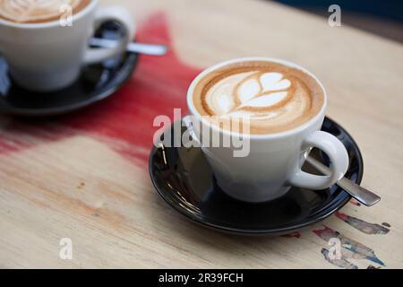 Un café blanc plat sur une table Banque D'Images