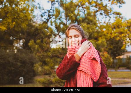 Fille dans un manteau bordeaux et une écharpe rose Banque D'Images