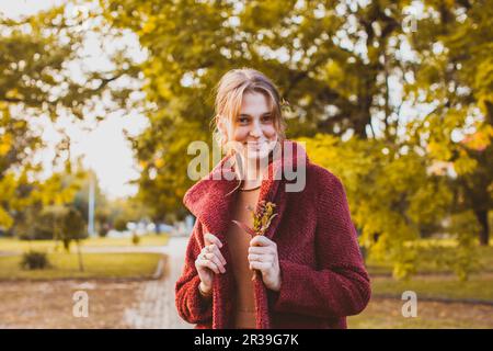 Portrait d'une fille dans un manteau bordeaux Banque D'Images