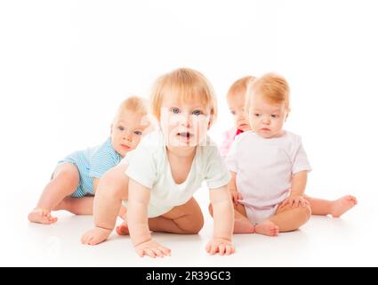 Groupe de bébés drôles assis sur fond blanc, isolé Banque D'Images