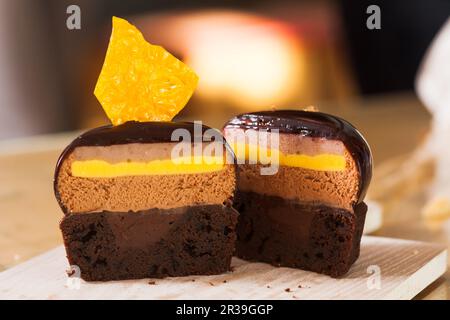 La moitié du gâteau à la mousse française recouvert de glaçage au chocolat Banque D'Images