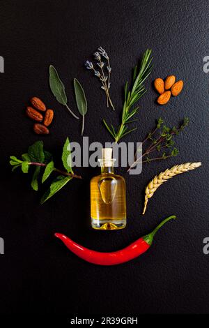 Bouteille d'huile essentielle aux herbes sur fond noir. Cosmétiques biologiques sains Banque D'Images