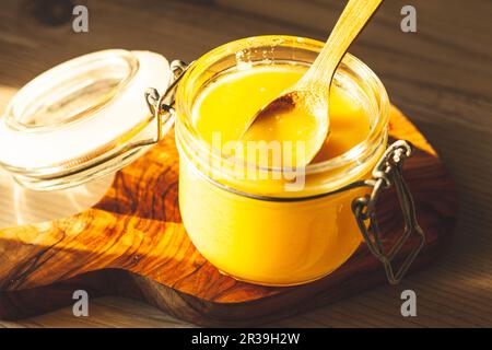 Cuillère en bois avec ghee - beurre clarifié sur la cuisine Banque D'Images