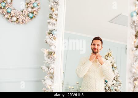 Jeune homme se regardant dans un grand miroir Banque D'Images