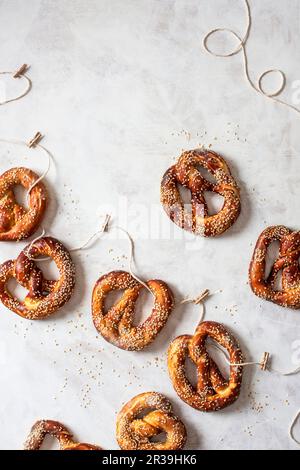 Bretzels faits maison avec des graines d'assaisonnement sur une corde Banque D'Images