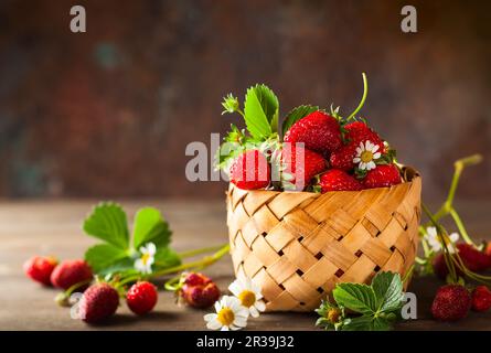 Fraise fraîche dans un panier sur fond de bois Banque D'Images