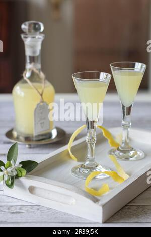 Limoncello dans une carafe et deux verres sur un plateau en bois Banque D'Images