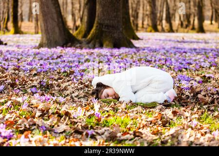 Portrait de petite fille mignonne parmi les fleurs du premier printemps Banque D'Images