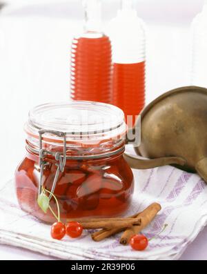 liqueur maison faite avec des cerises aigres conservées et des bâtons de cannelle Banque D'Images