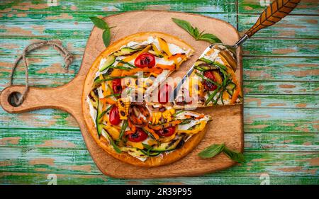 Délicieux hors-d'œuvre d'été : pizza végétarienne avec légumes grillés et fromage doux sur bois. Vue de dessus Banque D'Images