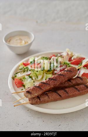 Brochettes d'agneau grillées avec salade Banque D'Images