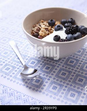 Muesli au yaourt, aux myrtilles et aux mûres dans un petit bol Banque D'Images