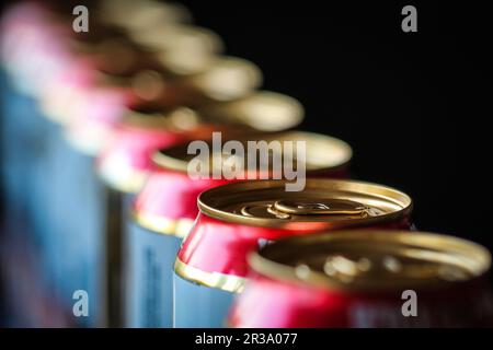 Boîtes de bière dans une rangée contre Banque D'Images