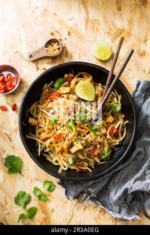 Bol sombre de cuisine thaïlandaise, tofu, nouilles et légumes Banque D'Images