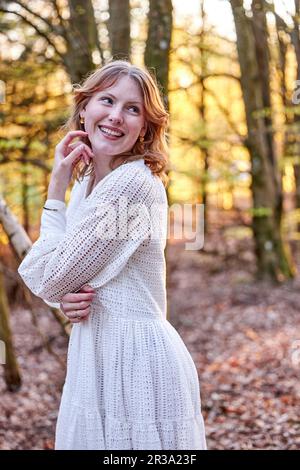 redhead fille en robe blanche en forêt Banque D'Images