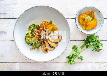 Brocoli rôti aux champignons portobello, abricots au Chili et houmous (vegan) Banque D'Images