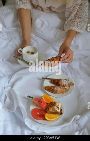 Petit déjeuner au lit croissants fruits et café Banque D'Images