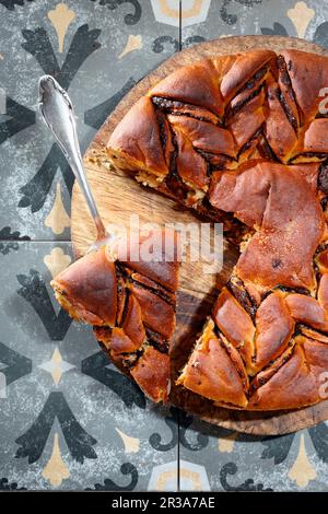 Gâteau de levure au chocolat sur une assiette en bois avec un serveur à gâteau Banque D'Images