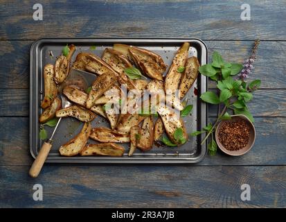 Aubergine rôtie sur plaque de cuisson avec épices et basilic Banque D'Images