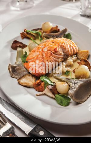 Saumon sauvage avec risotto aux champignons, chantarelles, smitake, coeurs d'artichaut et oignons perlés glacés Banque D'Images