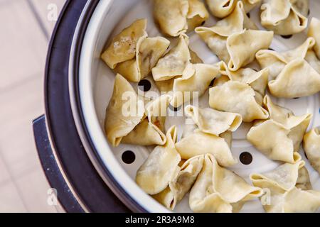 Cuisson de pâtes, raviolis, gedza dans un cuiseur vapeur Banque D'Images