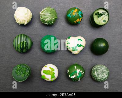 Chocolats faits à la main. Bonbons au chocolat colorés sur fond de plateau en ardoise grise Banque D'Images