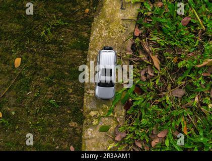 Concept pour voyager avec une voiture. Photo d'une voiture-jouet placée dans le parc, après quelques modifications. Banque D'Images