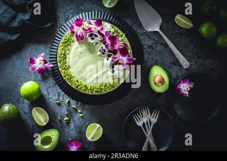 Cheesecake à l'avocat et au citron vert décoré de fleurs et de pistaches Banque D'Images